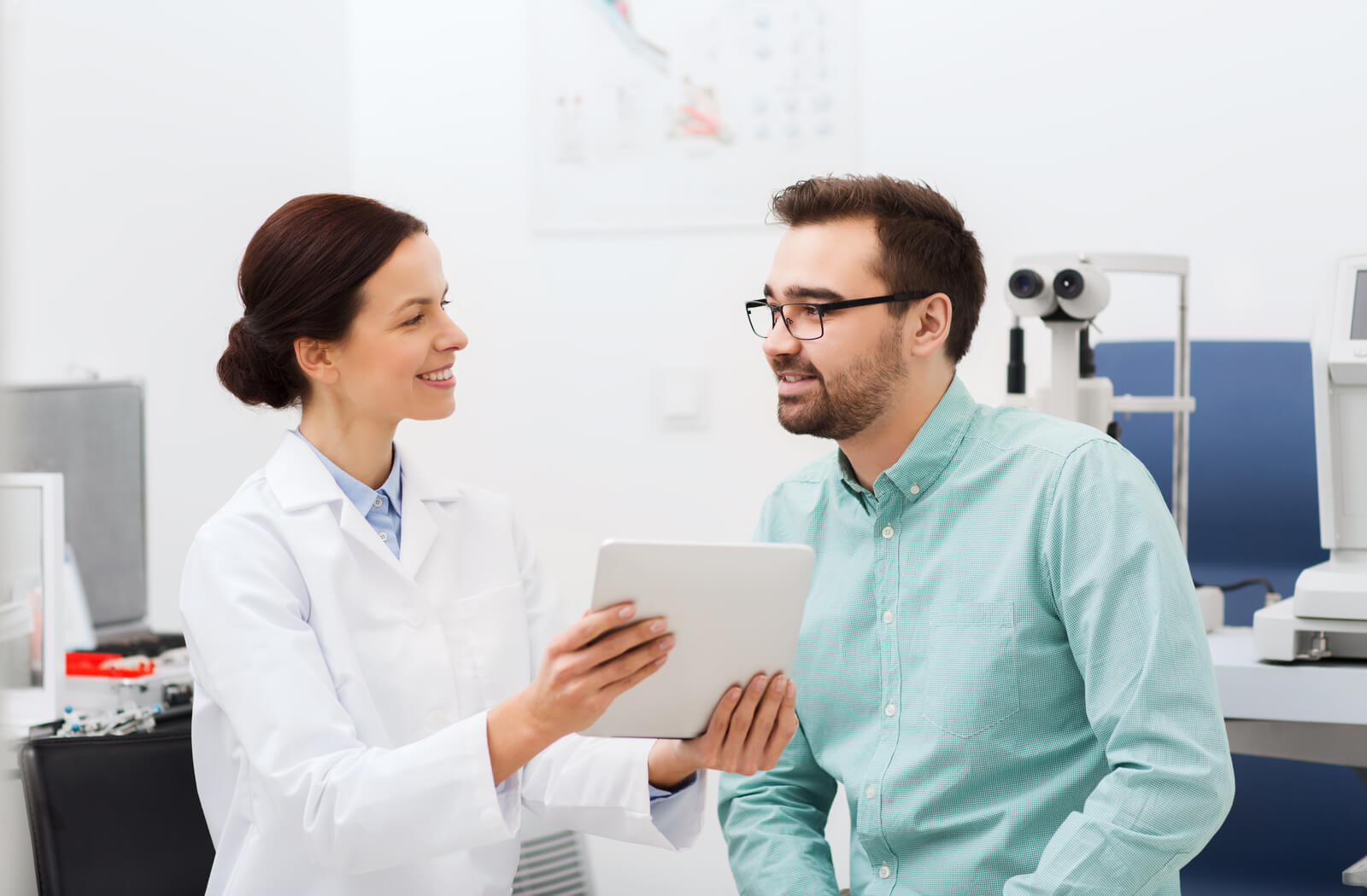 A female optometrist talking to a patient and giving him some paperwork