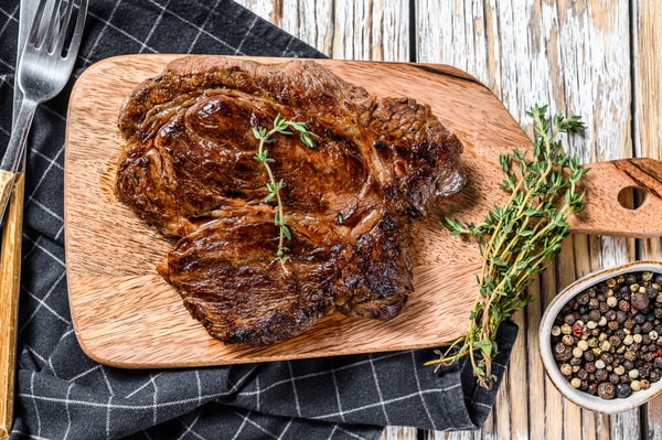 Grilled chuck eye with herb served on a wooden board