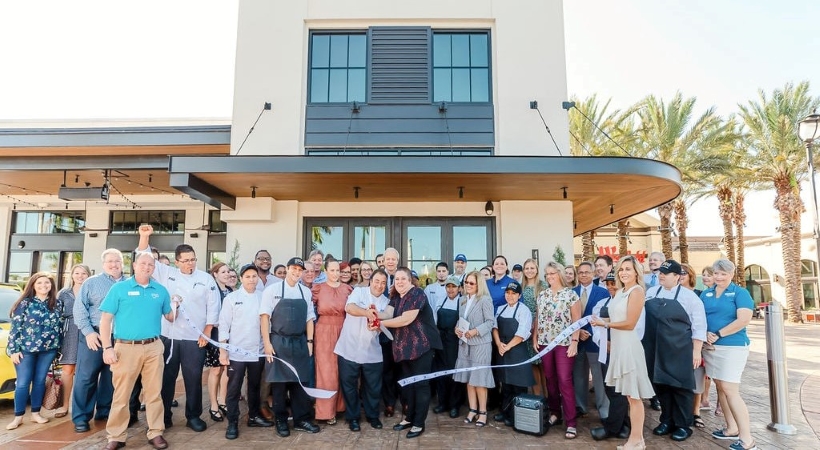 A group of people at a ribbon-cutting in front of a new business in Sarasota.
