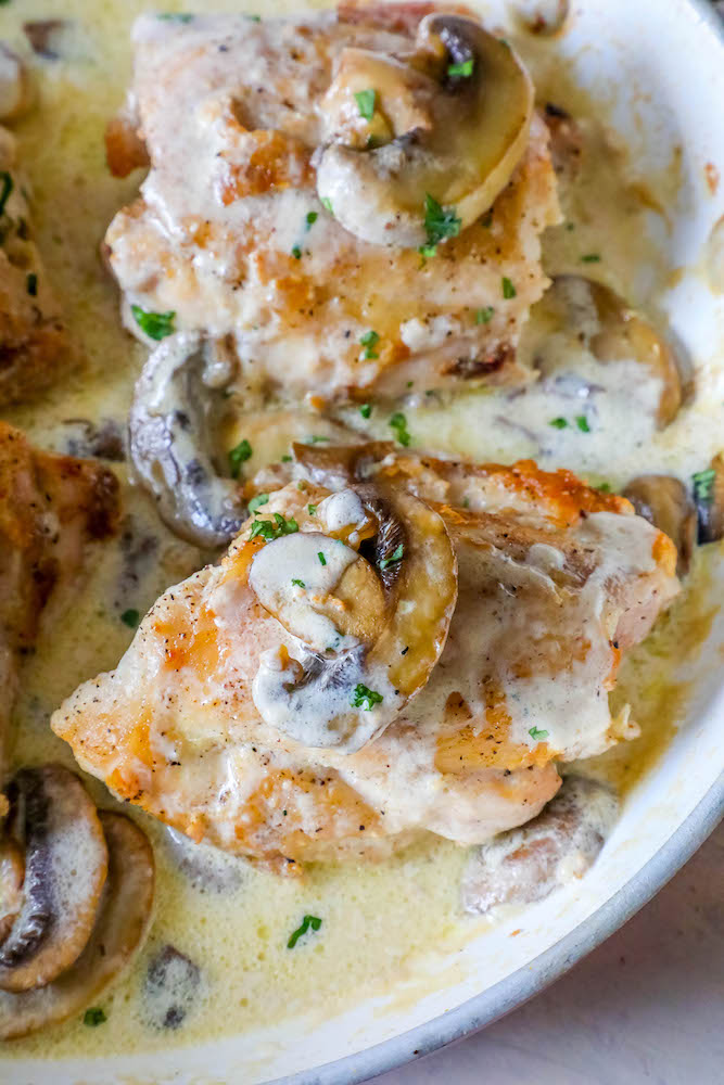 chicken thighs with mushrooms and a creamy garlic sauce in pan picture