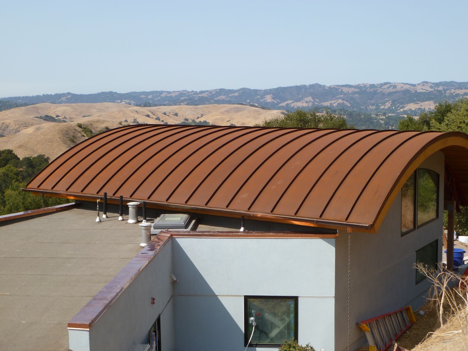 Concave curved standing seam metal roof in a Corten® finish