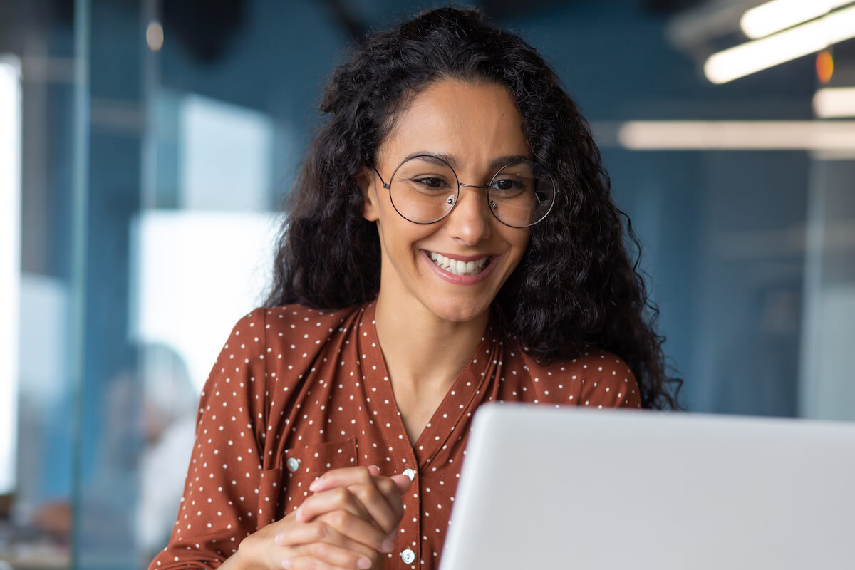 Patient journey: woman happily looking at a laptop