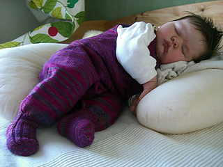 sleeping baby wearing purple footed onesie