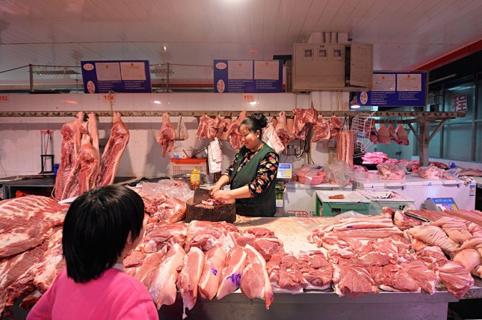 This picture taken on February 15, 2015 shows a Chinese butcher preparing slabs of pork for sale at a market in Beijing. (STR/AFP/Getty Images)