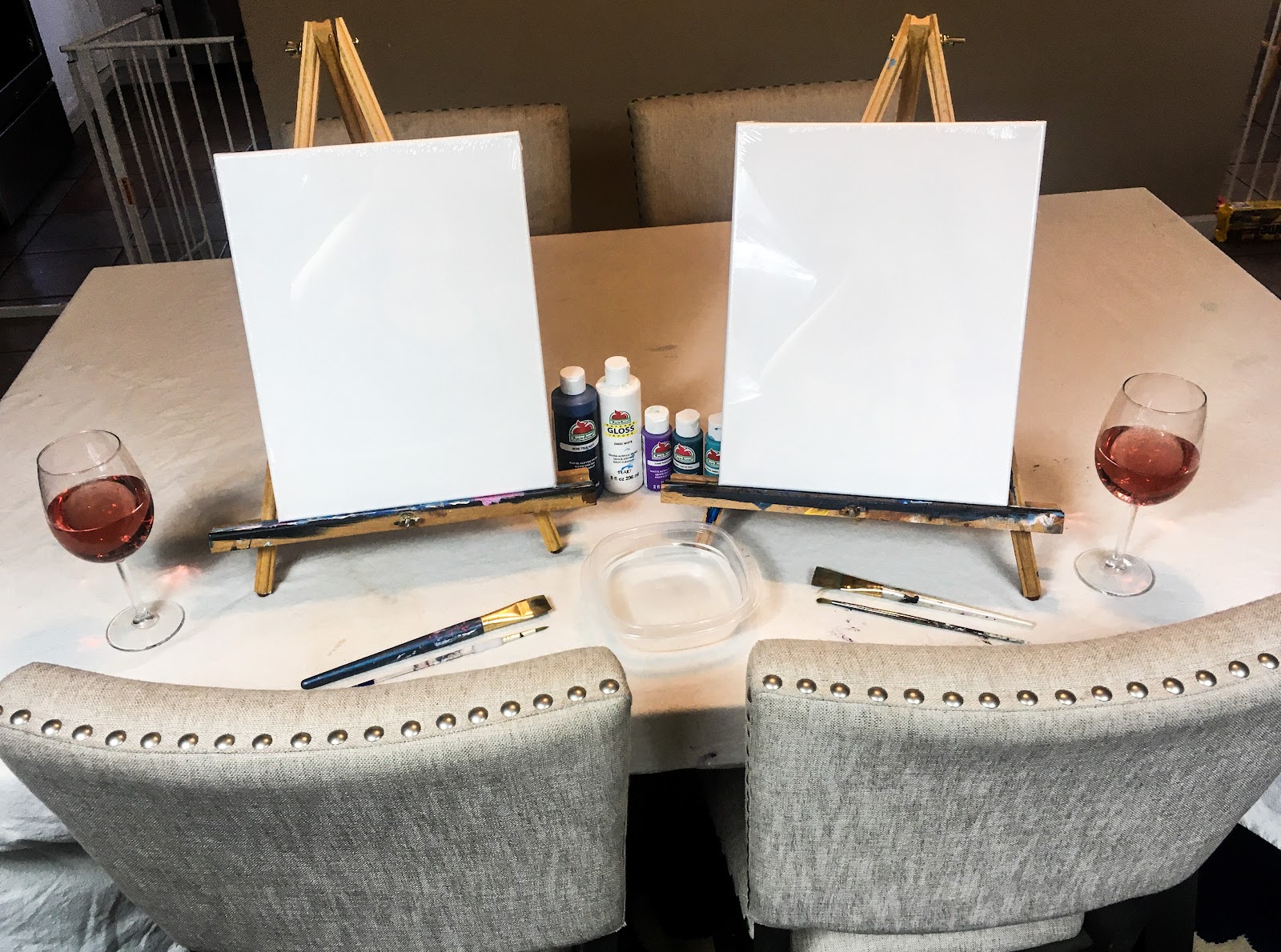 two blank canvases on easels with wine glasses for at home paint and sip night 