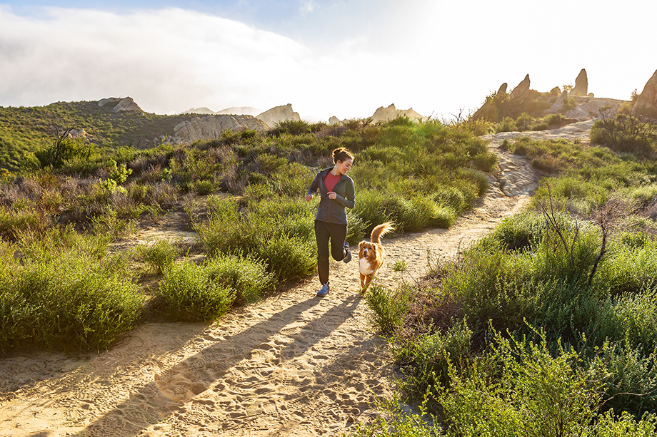 Model and dog run through lush canyon path on a bright sunny day, shot in the Santa Monica Mountains by Lou Bopp for Purina Pro Plan.