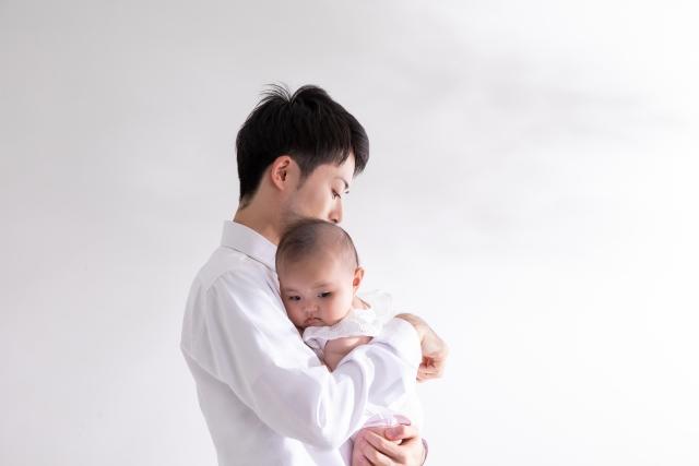 赤ちゃんを大切に抱きしめる男性の写真