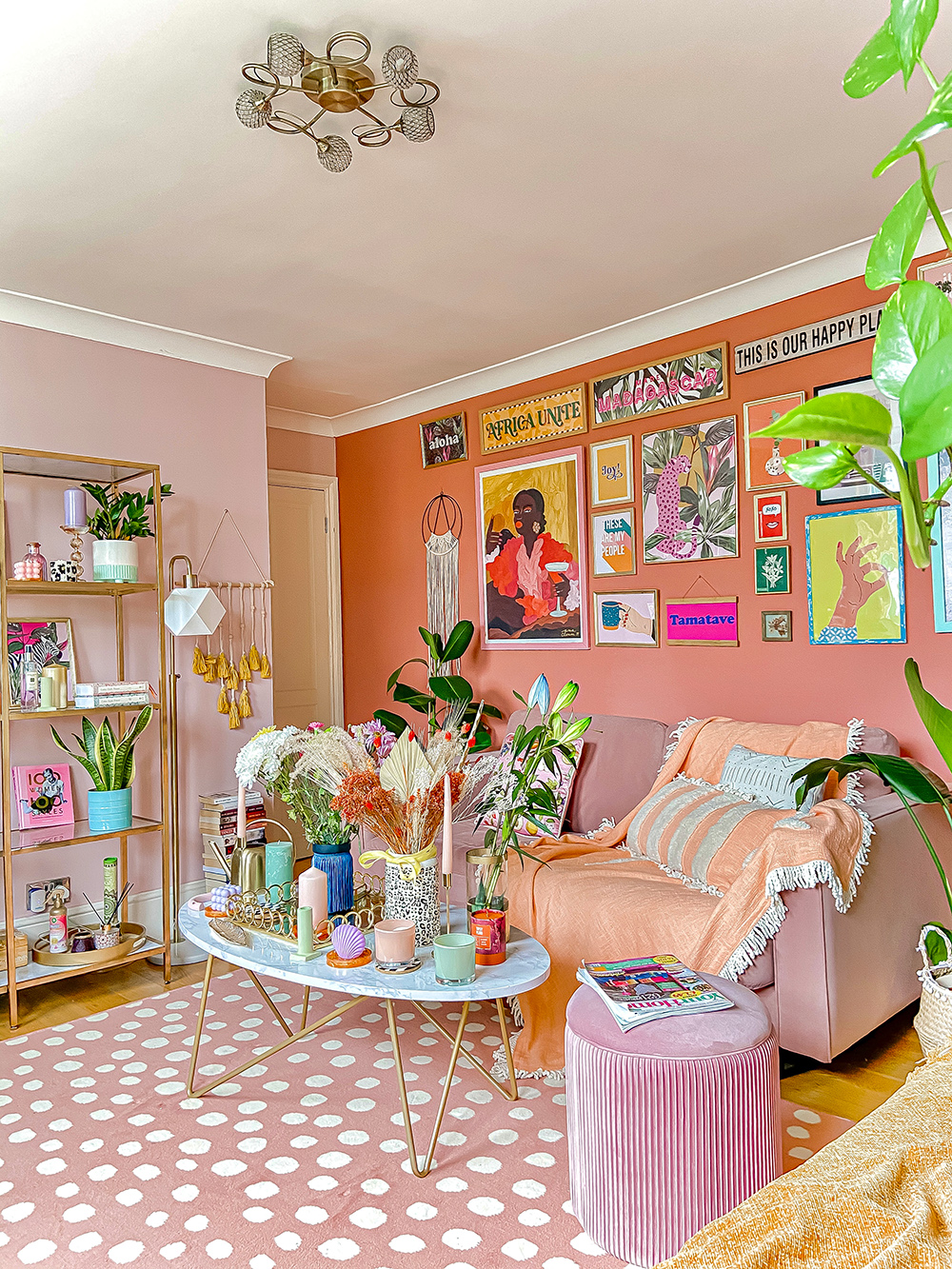 Very colourful boho inspired living room with pink spotted rug and lots of colourful accessories.