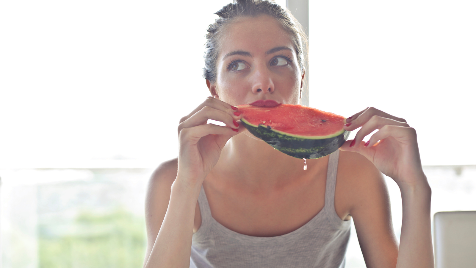 Woman eating a watermelon slice.