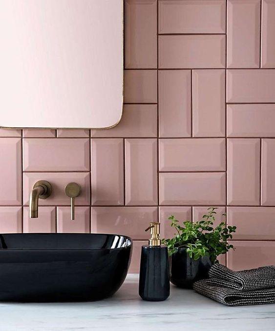 Banheiro com bancada da pia de porcelanato marmorizado branco, cuba e acessórios pretos, parede de fundo com azulejo subway tiles rosa e espelho