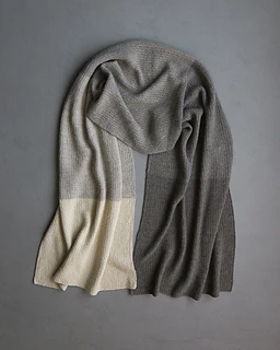 neutral toned scarf lying flat on dark gray background