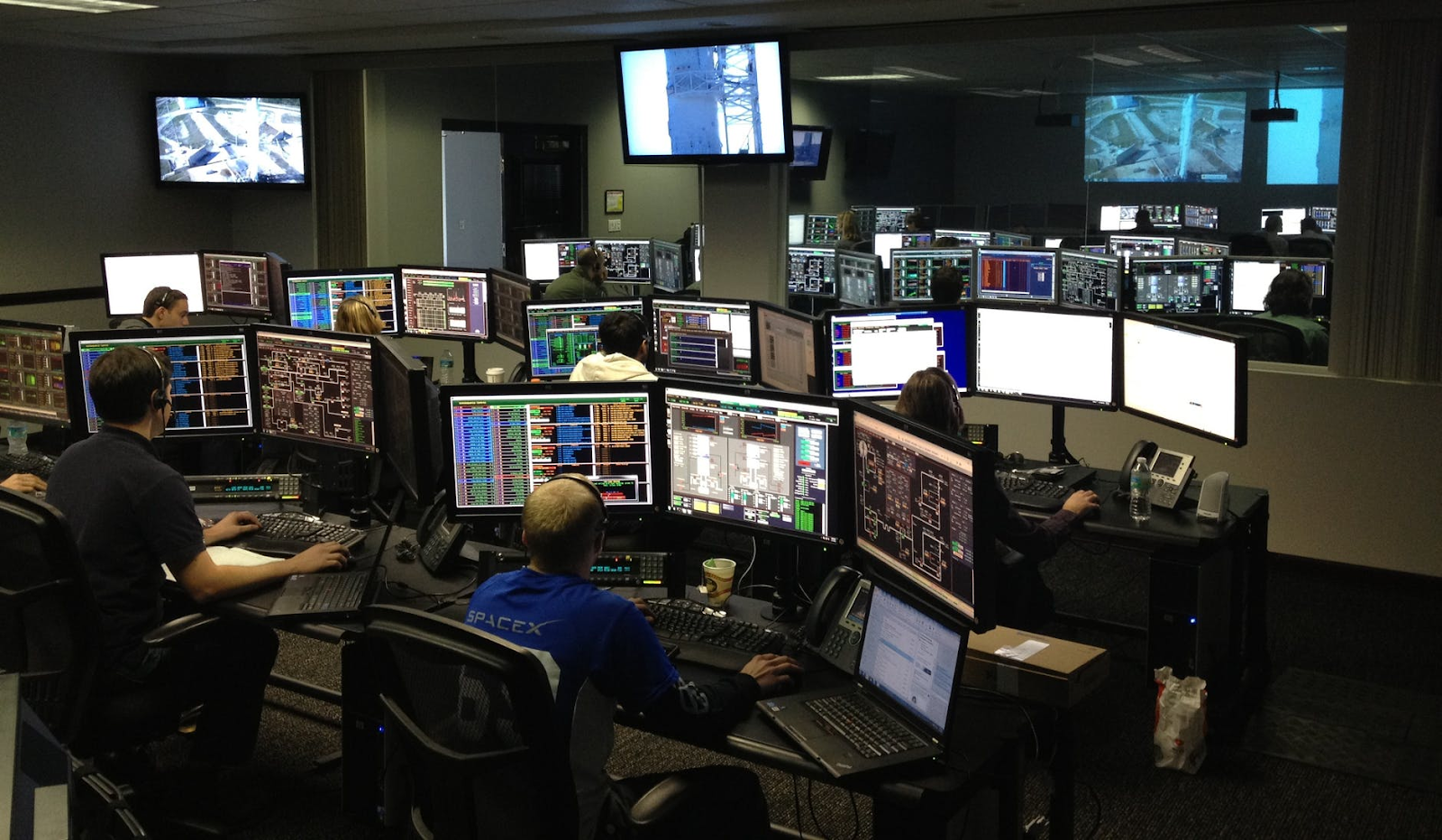 a busy IT room with workers attending to various tasks.