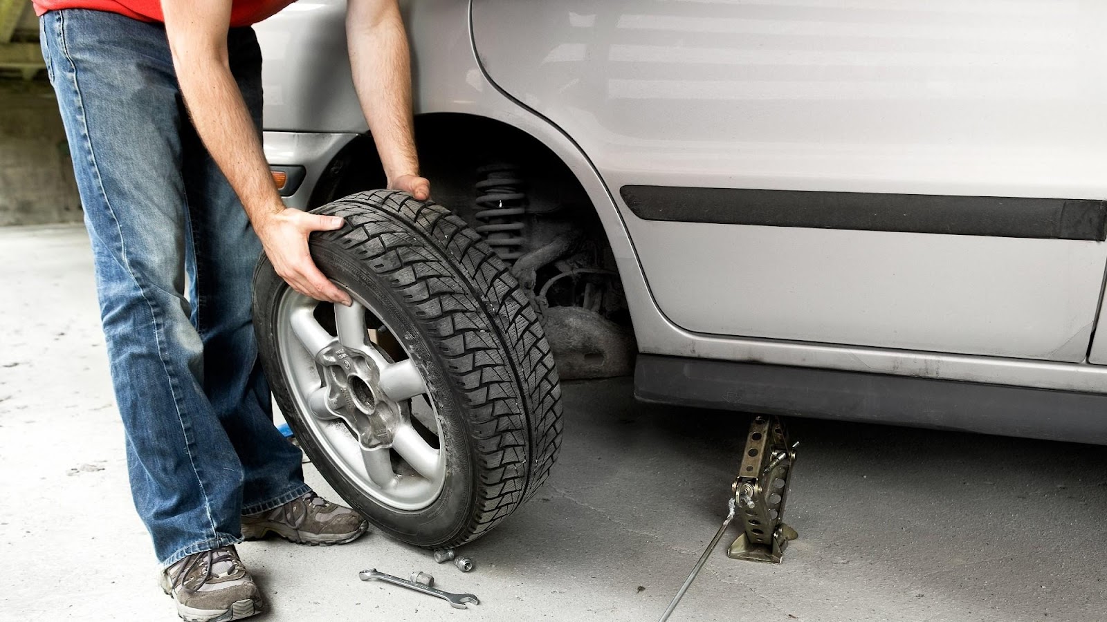 Removing a tire from a vehicle on jack stands to inspect for wear that causes shaking