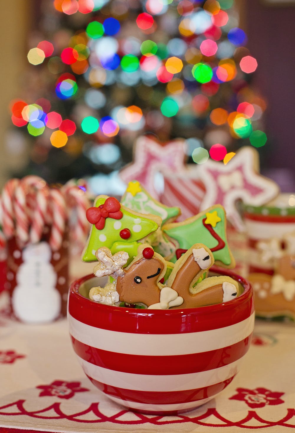 colorful sugar cookies in a red and white striped mug