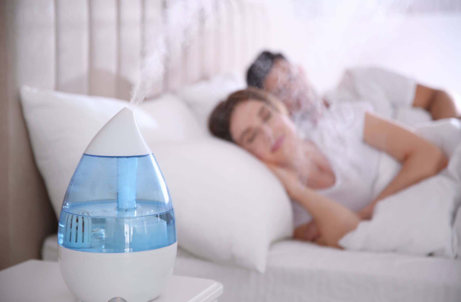 a couple sleeps with a humidifier in their room to help alleviate dry eye in the morning