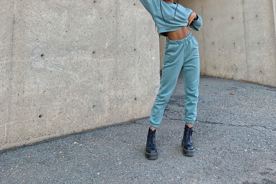 Lady in black boots wearing performance light green joggers