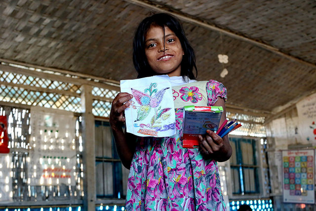 A Rohingya girl proudly holds up her drawing at a UNICEF school at Balukhali camp, Bangladesh. Credit: Farid Ahmed/IPS