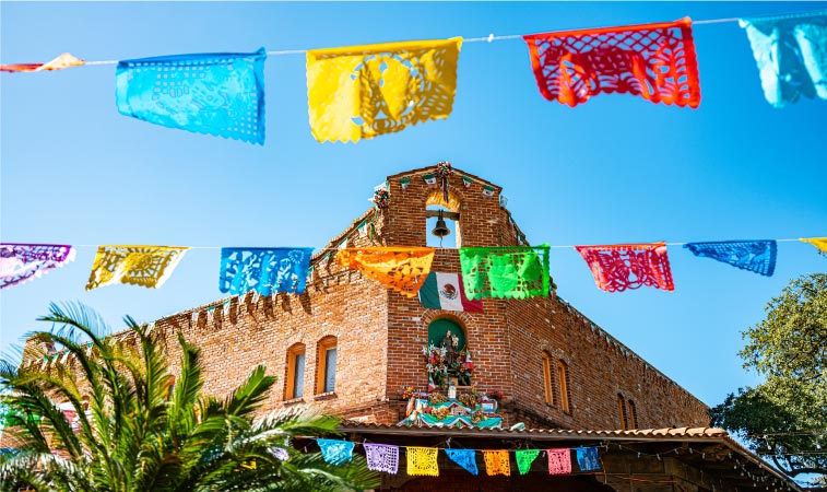 Colorful Mexican paper decorations hang between buildings in downtown San Antonio’s historic Market Square. 