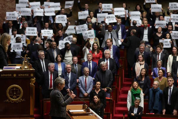 France’s Parliament, crowded with lawmakers holding signs.