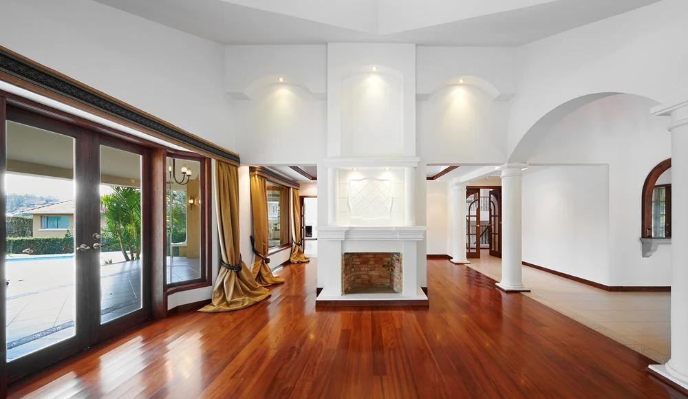 A view of a living room with hard wood floors and a large window

Description automatically generated