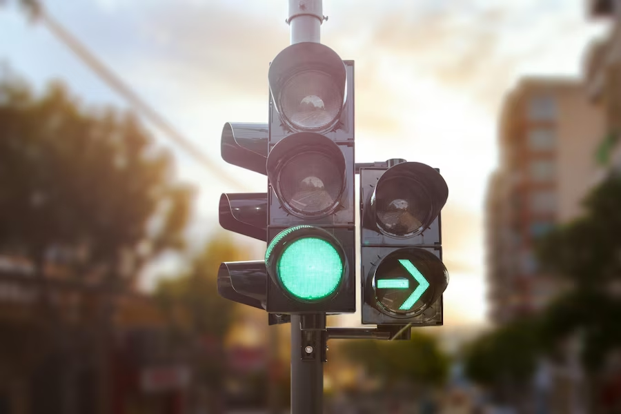 A green traffic light with illuminated green arrow