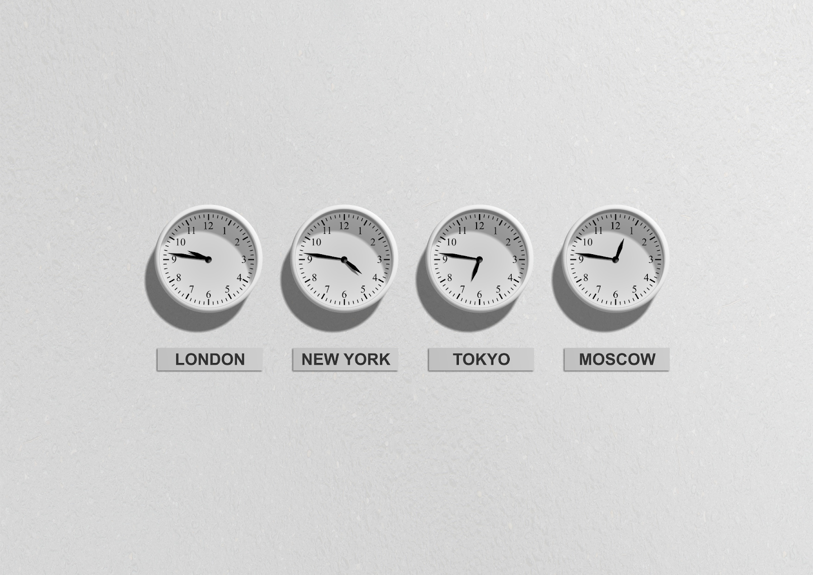 Different time zones represented by four clocks; one from london, one from new york, one from tokyo, and one from moscow
