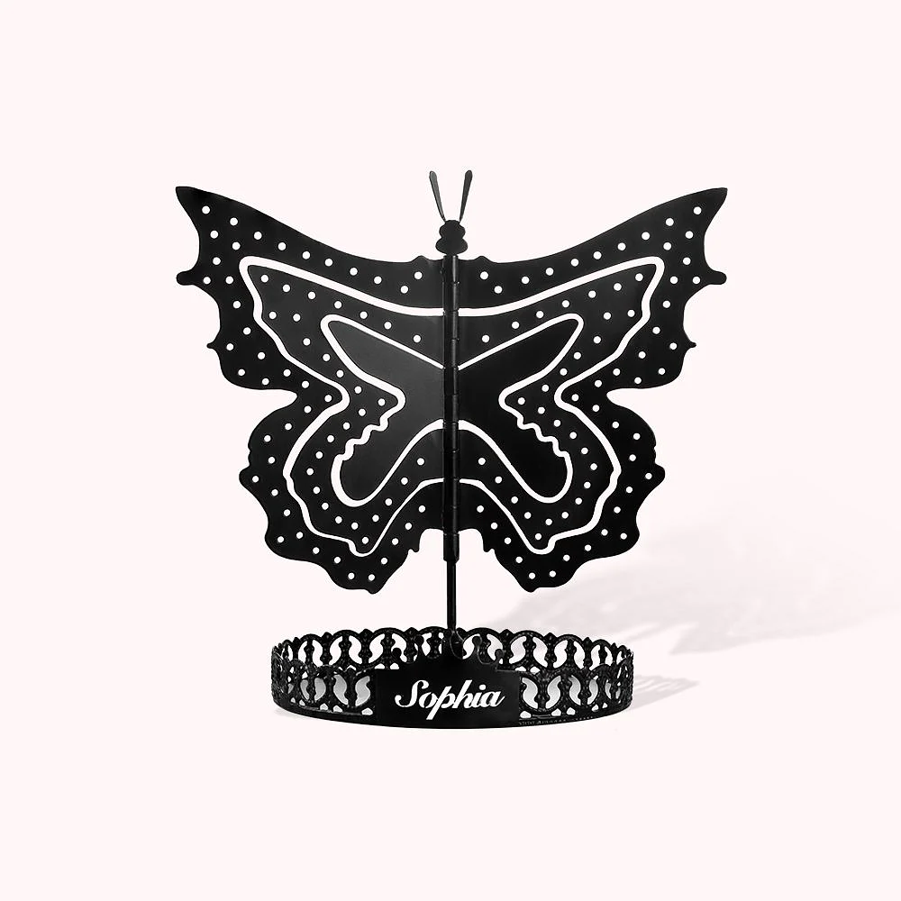 Porte-bijoux noir en forme de papillon monté sur un support circulaire personnalisé avec un prénom. 