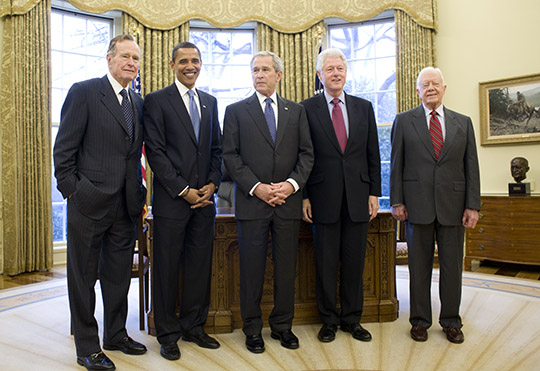 Then-President of the United States of America, George W. Bush (center), invited then-President-Elect Barack Obama (second from left) and (from left to right) former Presidents George H.W. Bush, Bill Clinton and Jimmy Carter for a meeting and lunch at the White House on Jan. 7, 2009, seen here in the Oval Office. (Photo by Pete Souza, Obama-Biden Transition Project; source: commons.wikimedia.org).