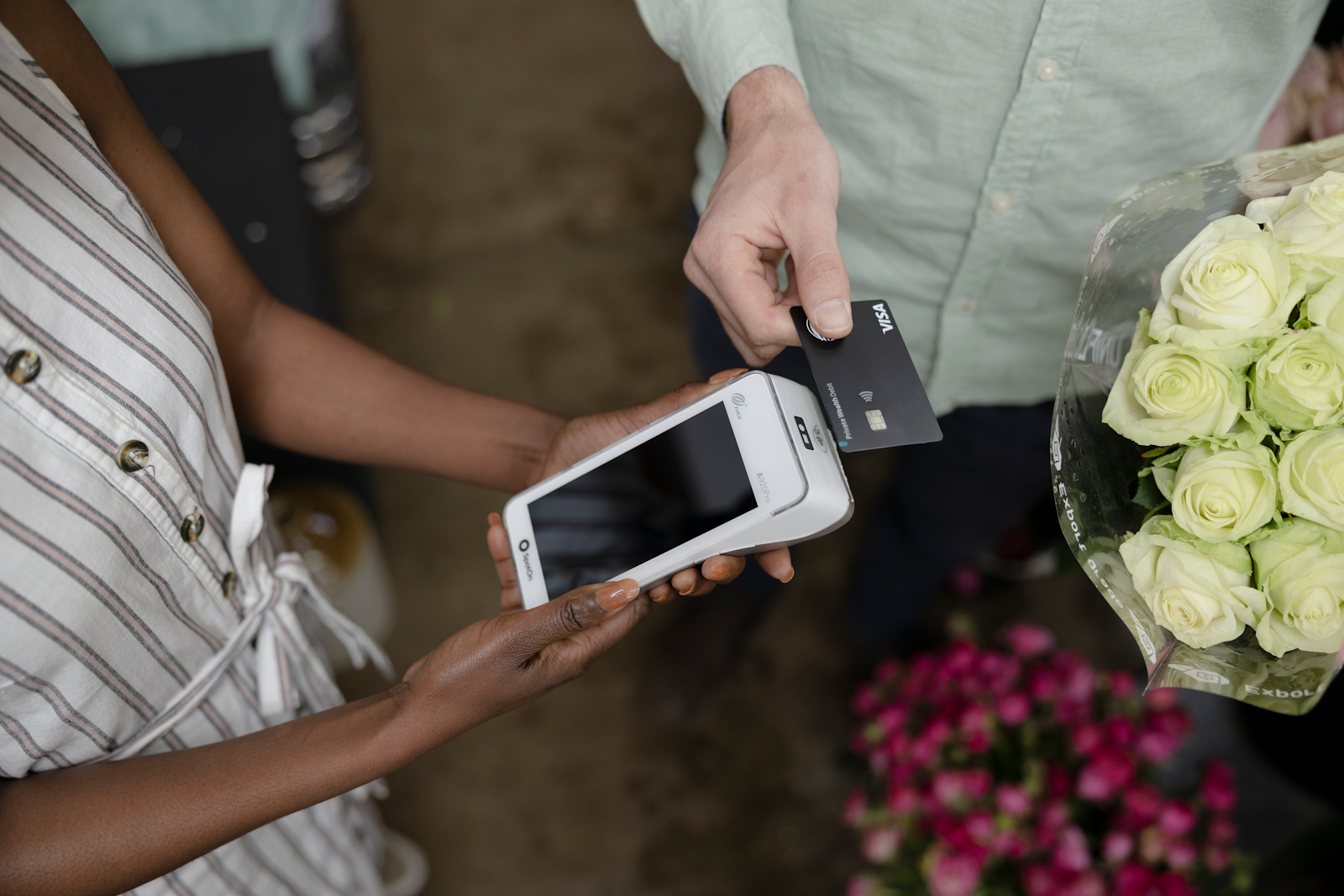 A customer taps to pay on a handheld POS