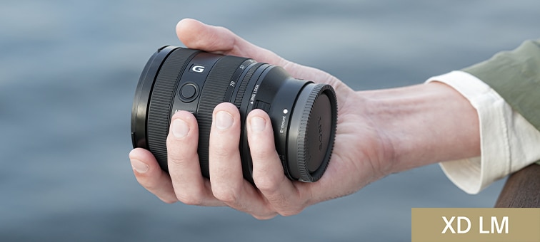 View of lens barrel held in user’s hand, emphasising compact size of the lens
