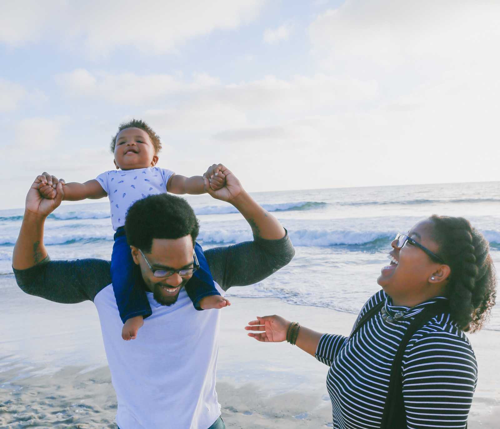 Smiling family of three on a beach