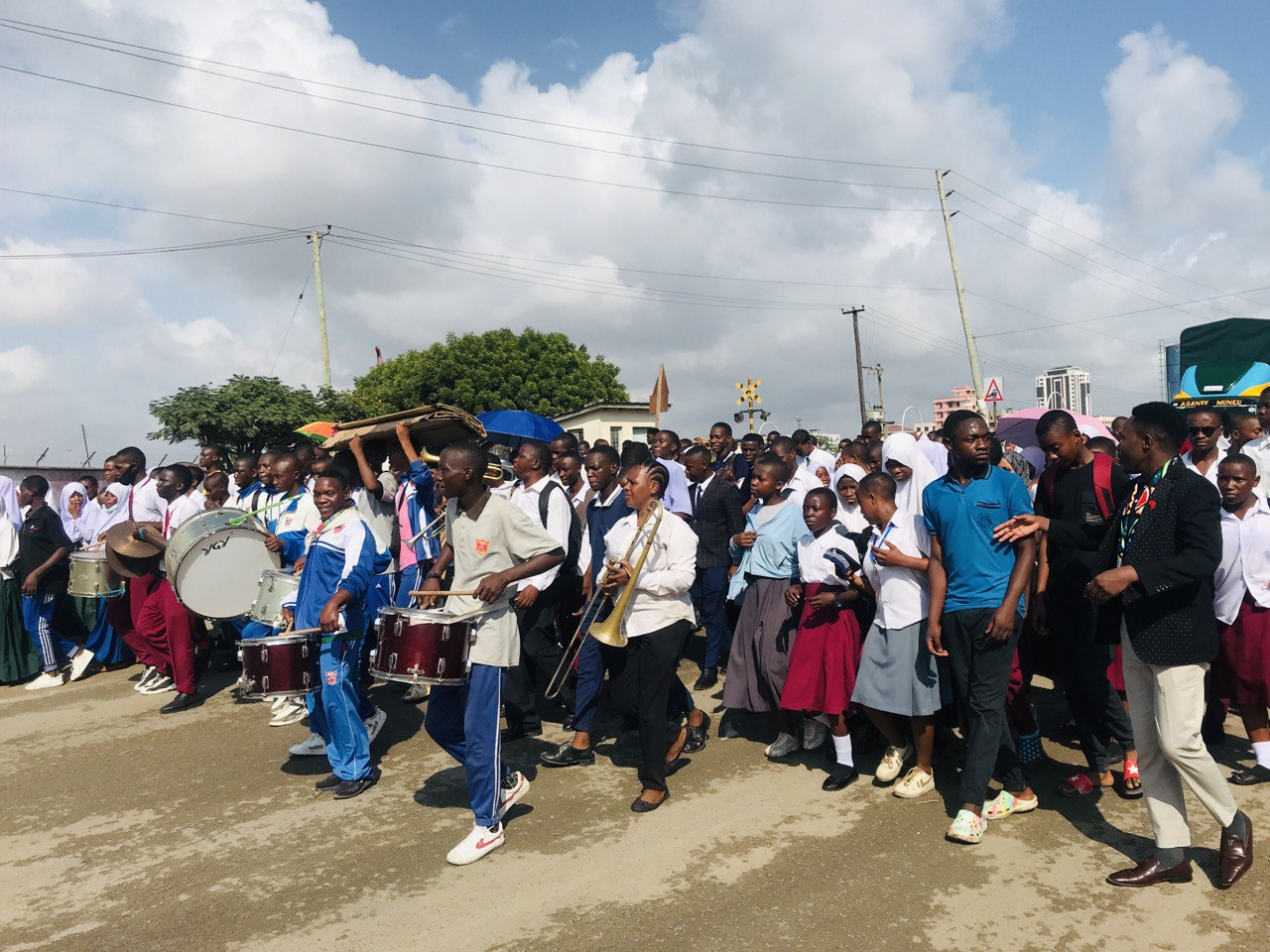 A crowd of adults and school children march but with no banners.