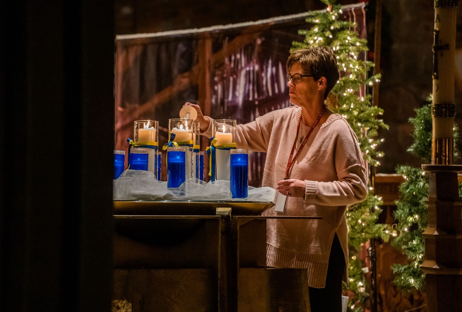 A woman lights a series of candles representing the 11 victims of the Oxford tragedy — four of whom died — during a memorial at St. Joseph Parish in Lake Orion. The parish was among several churches in the area who paid tribute to those lost and offered prayers for victims' families. (Valaurian Waller | Detroit Catholic)