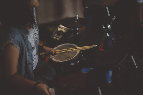 drummer sitting at drum kit holding drum sticks - how to mic drums