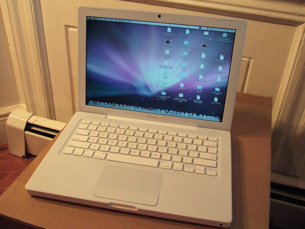 This image shows that the MacBook Pro 2022 in white color is in the table with open display.