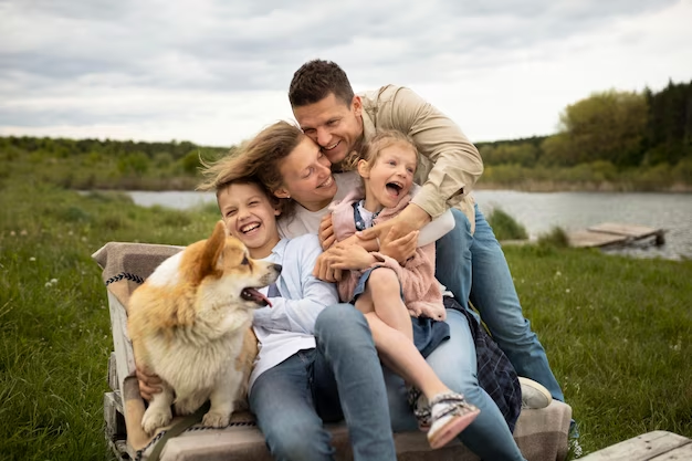 Happy family of four and a pet embracing each other.