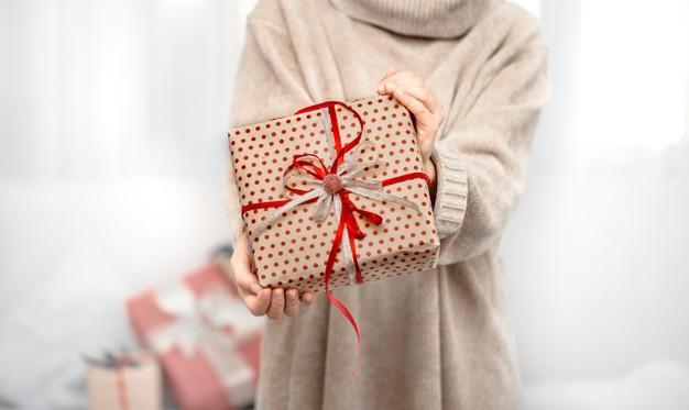 A woman is holding a beautiful christmas gifts. Free Photo