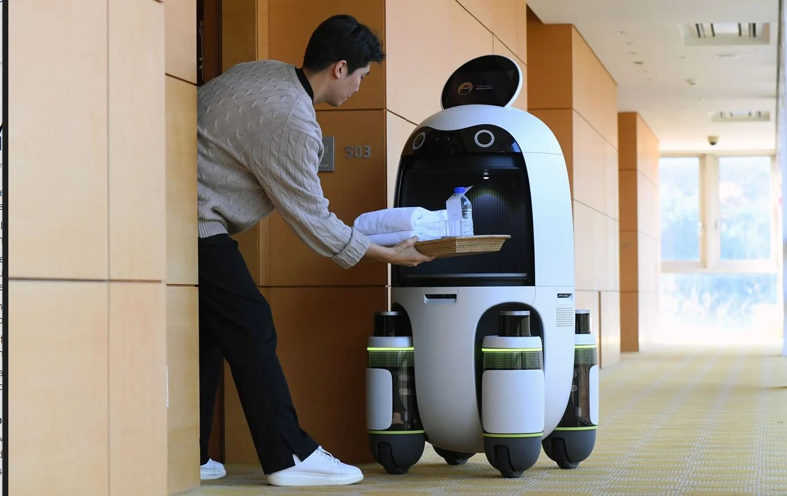 A hospitality robot delivering towels to a guest at a hotel. 