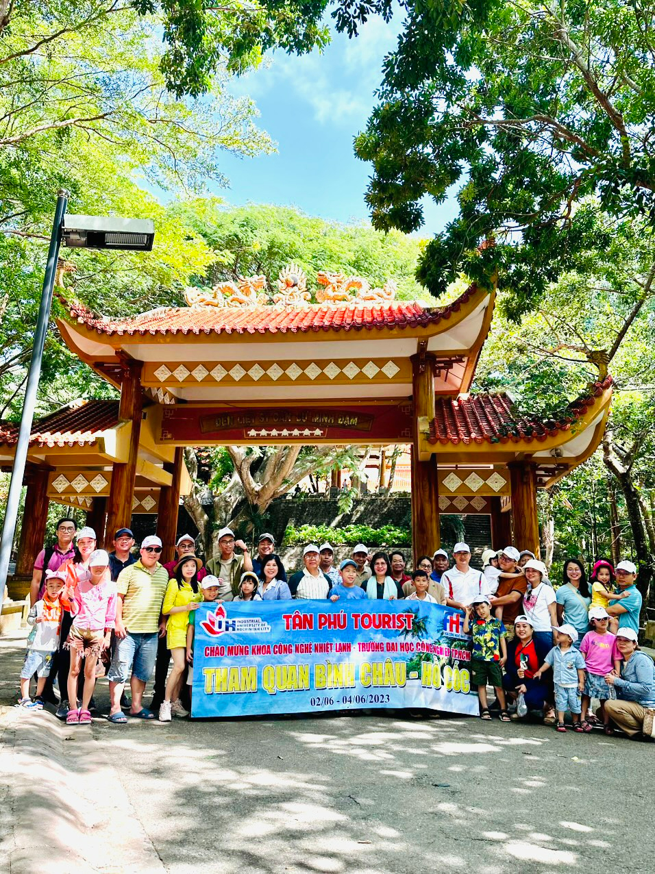 A group of people standing under a large bannerDescription automatically generated