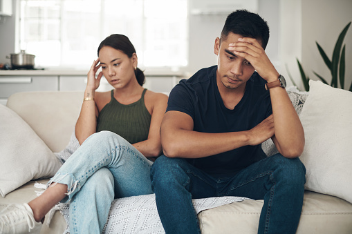 An Asian-American couple sitting on their living room couch, turning away from each other as they feel frustrated and overwhelmed and stuck in their relationship due to lack of conflict resolutions and trouble communicating.
   
        If you are having constant fight with your partner and are unable to fix the problems in your relationship, our couple's counselors in Woodland Hills, CA can help to improve your communication skills. Call today. 90077 | 91324 | 91364 | 91411 | 91436