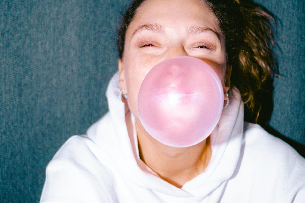 a woman blowing a chewing gum