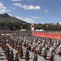 Tibetan dancers at the rally. The banner reads "Warmly celebrating the 50th anniversary of the creation of the Tibet Autonomous Region."