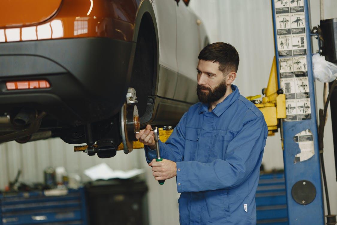 Free Mechanic Fixing the Under Chassis of a Car Stock Photo
