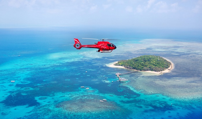 Helicopter flying over island