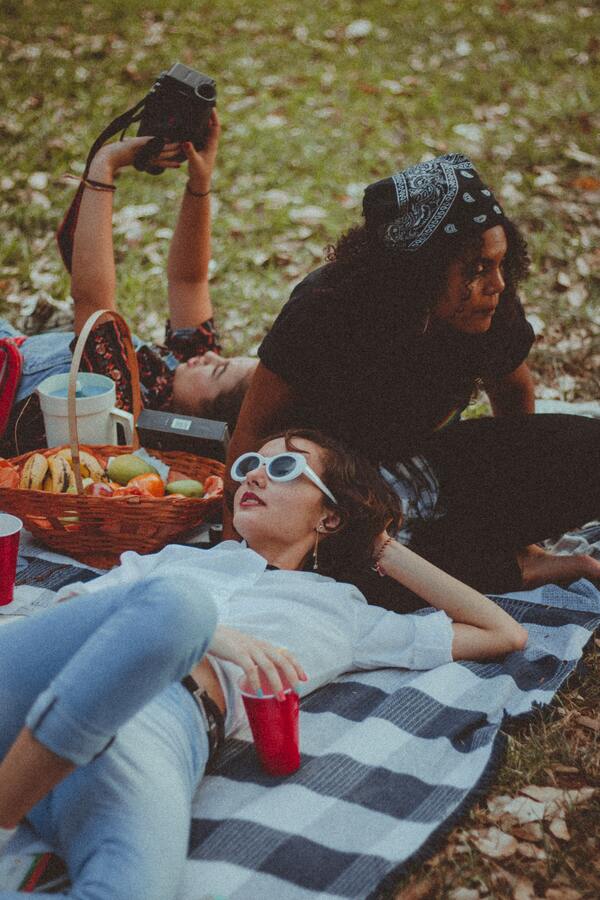 amigas deitada na grama durante um pic nic