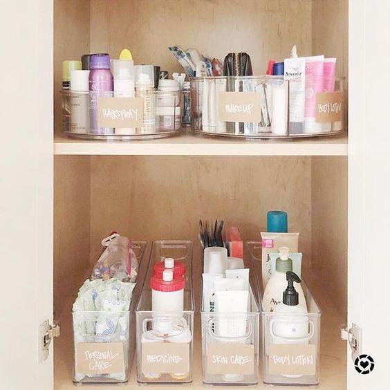 organizing bathroom closet with labeled clear containers