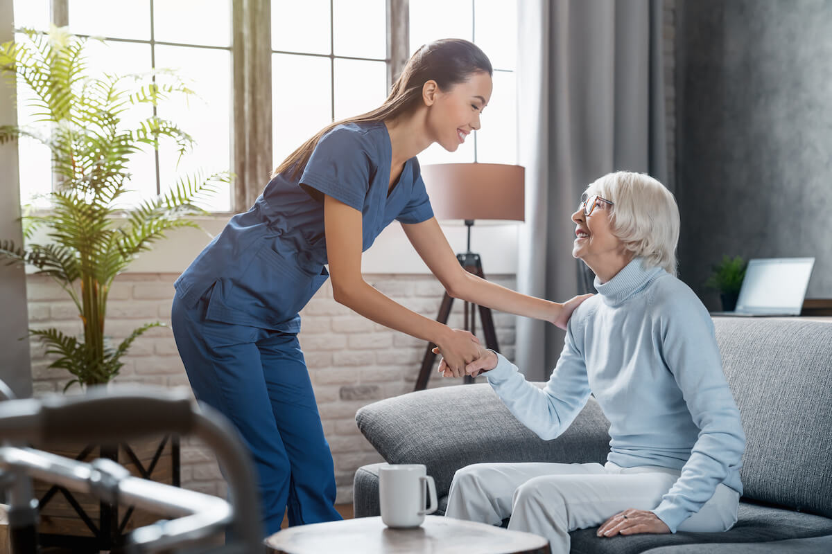 Types of electronic health record systems: nurse helping an elderly woman