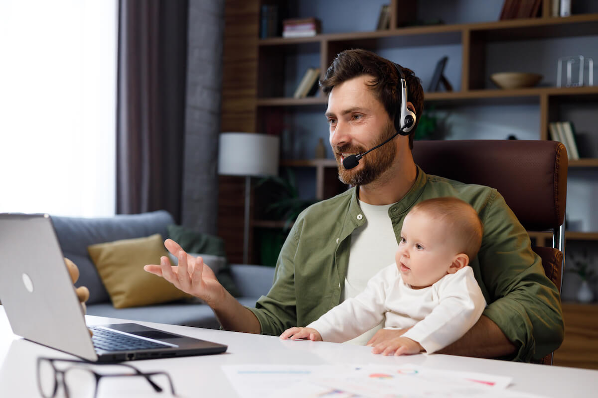 FMLA Colorado: father having a meeting online while taking care of his baby