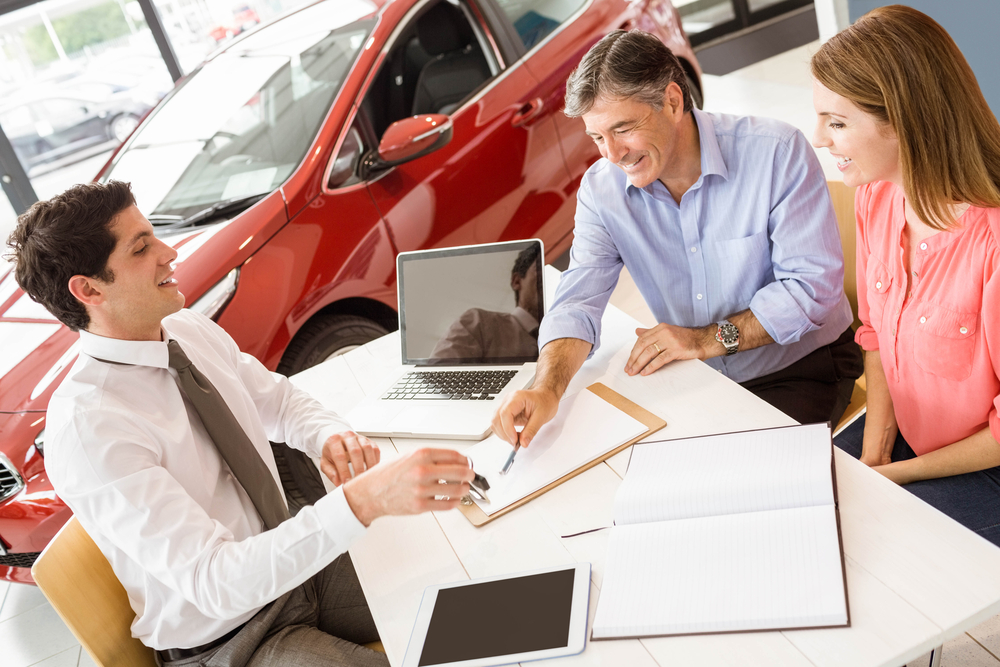 people at dealership talking to an agent about refinancing