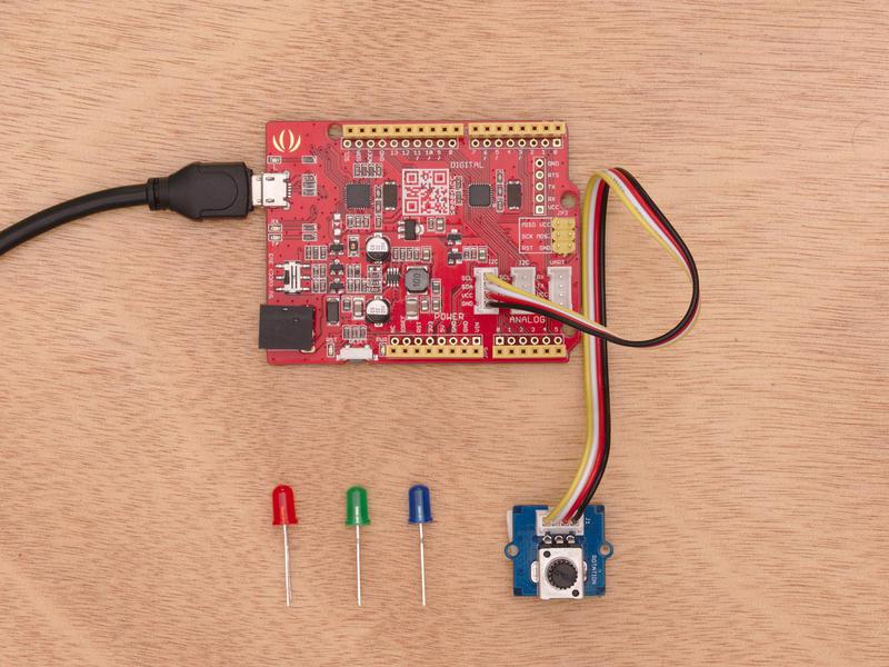 This is an image of all of the components inside Thimble's mini-starter STEM kit for elementary age students.  A red Arduino board is connected to a USB cable, with smaller components on the table around it.